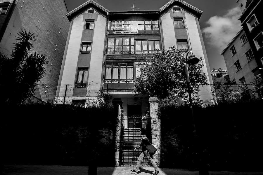 Un joven pasea por uno de los edificios de la calle Ramón y Cajal.