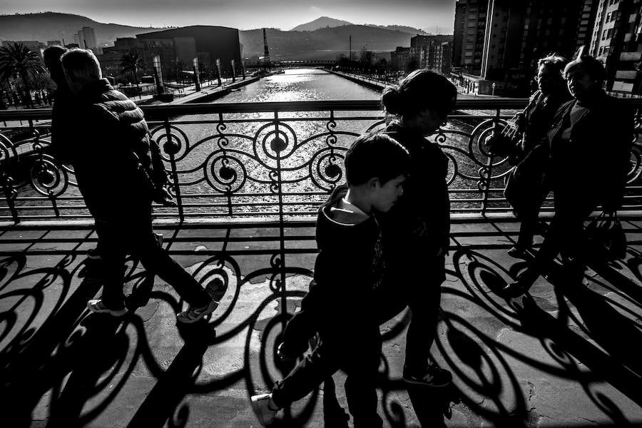Muchos bilbaínos pasean por el conocido puente de Deusto.