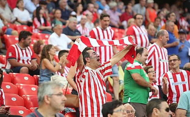 Aficionados posan en la puerta de un bar antes del partido. 