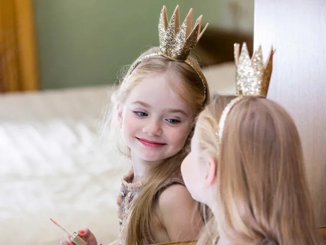 Una niña, con una corona de princesa.