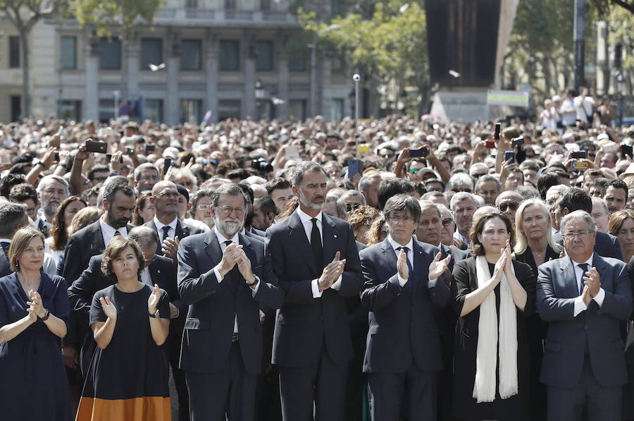 El rey Felipe VI, acompañado de la vicepresidenta del Gobierno, Soraya Sáenz de Santamaría (i), el presidente del Ejecutivo, Mariano Rajoy (2i), el presidente de la Generalitat, Carles Puigdemont (2d), y la alcaldesa de la ciudad, Ada Colau (d), guardan en la Plaza de Cataluña un minuto de silencio que ha terminado con largos aplausos y un grito de "no tengo miedo", por el dolor por los atentados de La Rambla de Barcelona y de Cambrils (Tarragona) ocurridos ayer. 