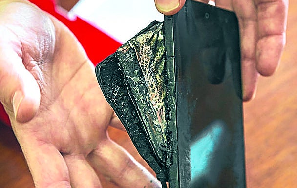 Xabier muestra su teléfono tras incendiarse de repente. 