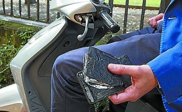 Xabier B., donostiarra de 39 años, sostiene en su mano el móvil quemado.