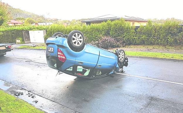 Antes de volcar, el coche derribó una árbol y una farola.