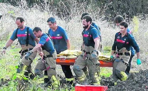 Los bomberos tras rescatar uno de los cuerpos sin vida.