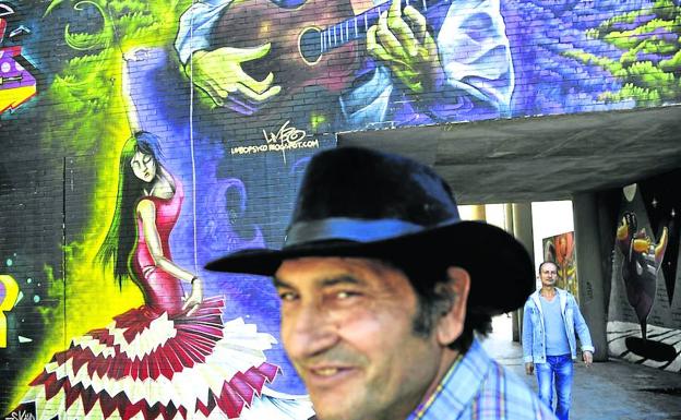 Flamenco en las calles. Ramón Santiago, con su amigo Miguel al fondo, delante de un mural en el que aparecen una bailaora y Paco de Lucía.