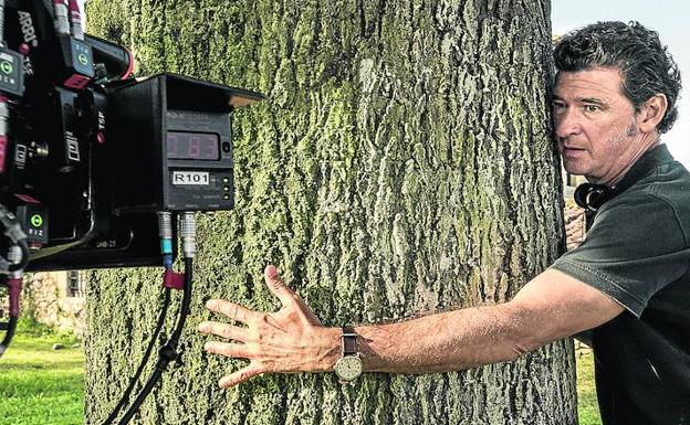 Julio Medem se abraza al árbol cuyas raíces son una metáfora de las tres familias protagonistas de su décimo largometraje.