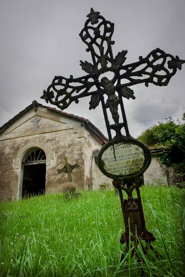 Una cruz de hierro forjado destaca entre el césped del pequeño camposanto de Abellaneda.