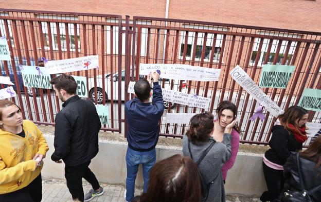 Jóvenes pegan carteles de repulsa junto al lugar del crimen. 