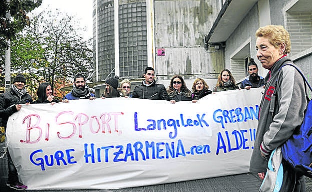 Una usuaria del polideportivo, frente a la pancarta de los trabajadores. 