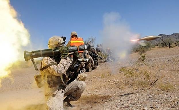 Imagen principal - El militar manipula un lanzagranadas antes de caer herido. Abajo, en la cancha y con sus hijos Jorge y Josué. 