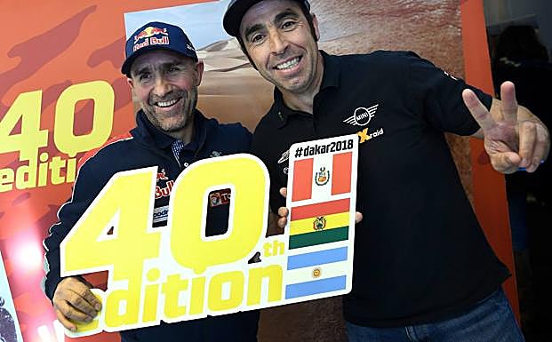 Stephane Peterhansel y Nani Roma, con el cartel del Dakar 2018. 