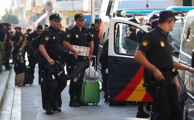 Agentes de la Policía Nacional abandonando el hotel en el que estaban alojados en Pineda de Mar. 