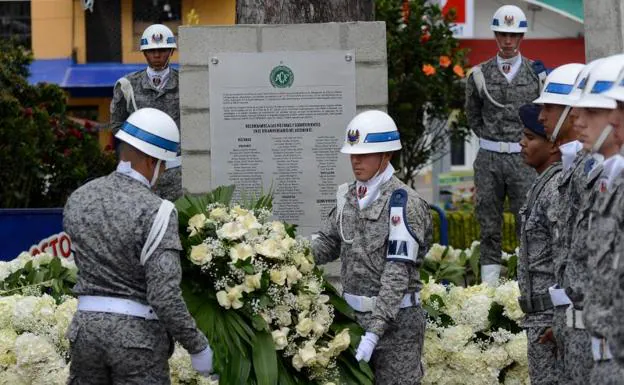Militares colombianos colocan una corona de flores en el mural dedicado a las víctimas. 