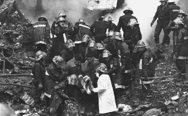 Los bomberos trabajan en el desescombro de las ruinas del cuartel de Zaragoza tras la explosión.