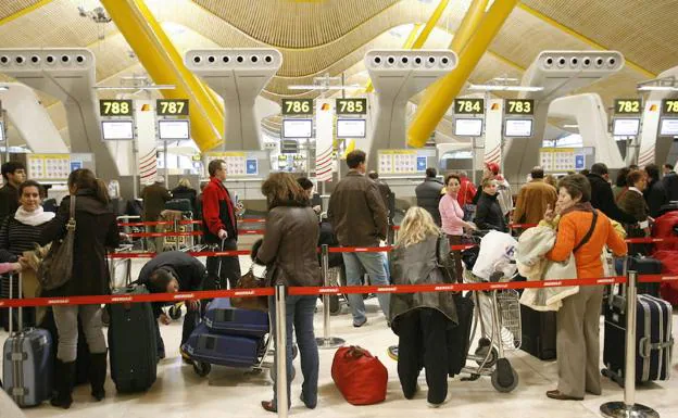 Numerosos viajeros esperan a facturar su maleta en el aeropuerto Madrid-Barajas.