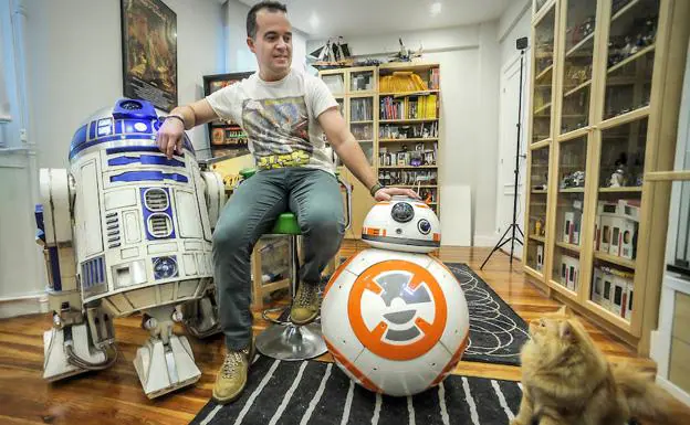Rafa Martín, con R2-D2, BB-8 y su gato Bassh en la habitación de su casa de Bilbao donde construye los robots de ‘Star Wars’.