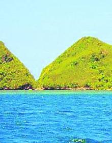 Imagen secundaria 2 - La escuela de secundaria de Bilbao y las colinas situadas en la boca de la bahía de Calanaga, donde se encuentra la población.