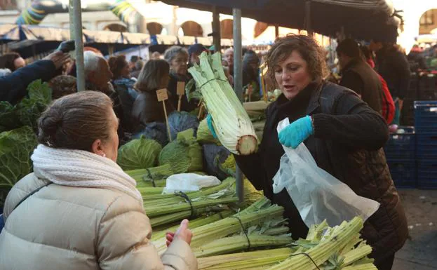 Una mujer compra un cardo en el mercado