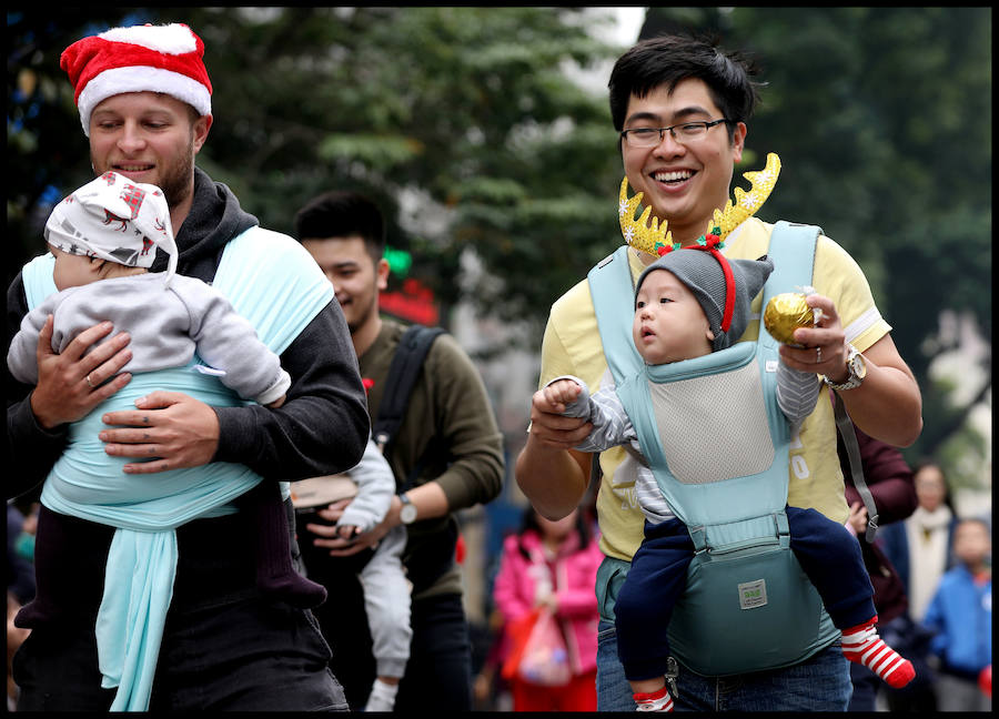 Madres con sus bebés se presentan durante un baile navideño en el centro de Hanoi. Las navidades no son una fiesta oficial en Vietnam. Sin embargo, algunas de sus costumbres se han vuelto más populares en los últimos años