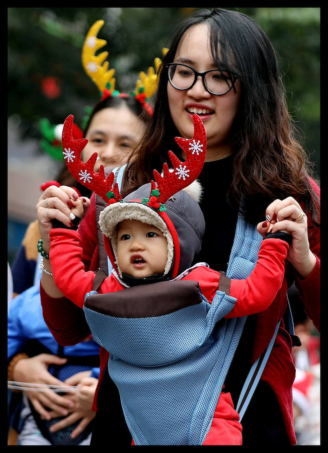 Madres con sus bebés se presentan durante un baile navideño en el centro de Hanoi. Las navidades no son una fiesta oficial en Vietnam. Sin embargo, algunas de sus costumbres se han vuelto más populares en los últimos años