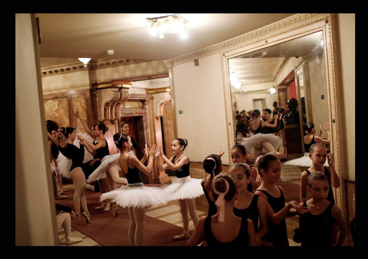 Los trabajadores del Teatro Municipal de Río, uno de los más prestigiosos de América Latina, dependen directamente del Estado de Río de Janeiro, que el pasado mes de julio decretó la situación de "calamidad financiera" para todo su territorio. La situación ha llegado a tal extremo que algunas bailarinas del ballet del teatro buscan dinero extra limpiando casas de amigas y el primer bailarín, Filipe Moreira, tuvo que vender su coche y ahora usa el de su madre para trabajar como conductor de Uber. El pasado primero de mayo se representó la ópera Norma, de Bellini, en forma de concierto, porque el coro debía ir a las funciones todos los días y no tienen dinero para desplazarse.