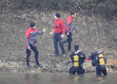 Imagen secundaria 1 - Buzos de la Ertzaintza trabajan en la orilla del pantano de Urrunaga en busca de Jon Bárcena (derecha).