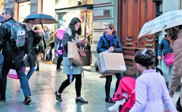 Clientas cargadas de bolsas con compras navideñas, una escena habitual estos días en las calles del centro.