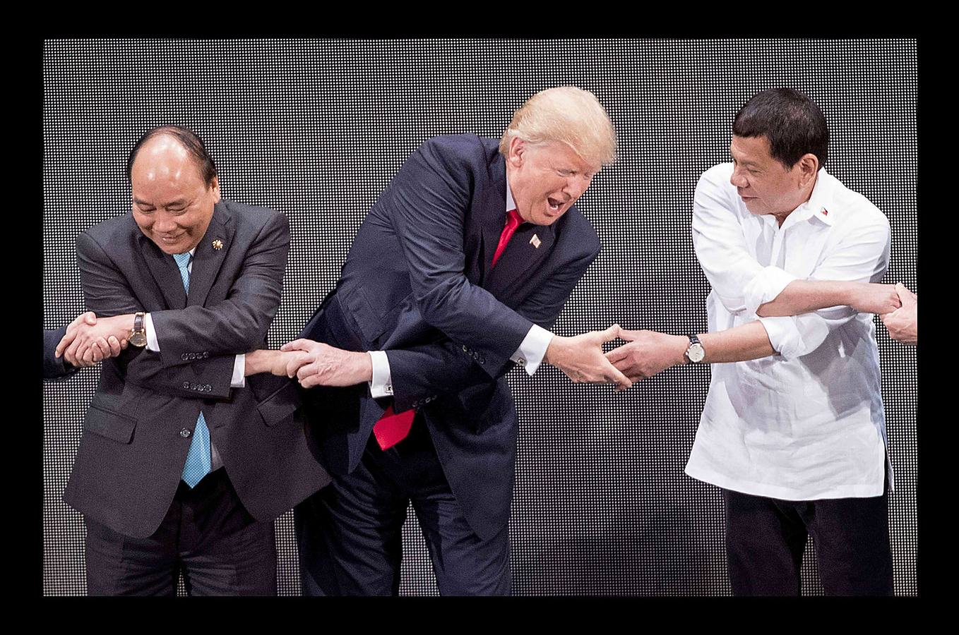 Nguyen Xuan Phuc, primer ministro de Vietnam, Donald Trump, presidente de EEUU, y Rodrigo Duterte, presidente de Filipinas, unen sus manos para la foto de familia durante el 31 aniversario de la Asociación de las naciones del sudese asiático.