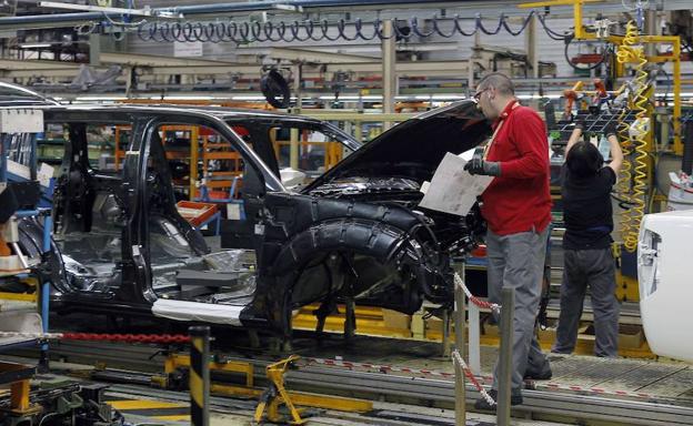Un operario revisa un de los vehículos en una planta de producción de automóviles.