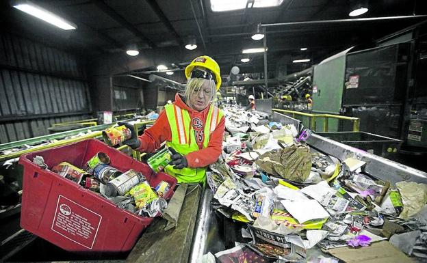 Un trabajador de una planta de tratamiento de residuos plásticos de Shenyang, al noreste de China, trata de abrirse paso entre un océano de envases. 