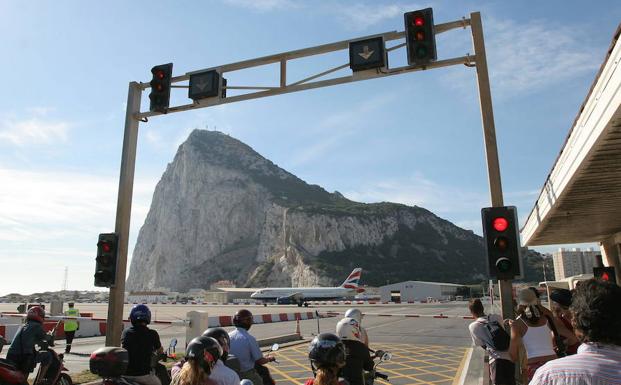 Vehículos esperan el paso de un avioneta por la pista de aterrizaje del aeropuerto de Gibraltar. 