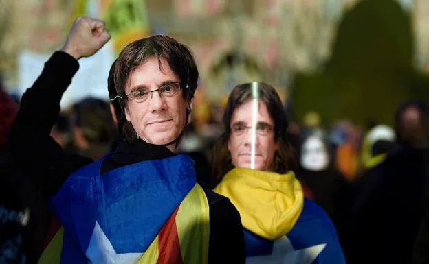 Manifestantes frente al Parlament con una careta del expresident Carles Puigdemont.