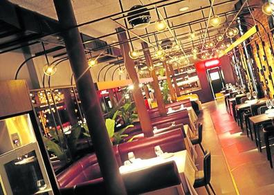 Imagen secundaria 1 - 1. Fernando Canales posa en su nuevo restaurante detrás de la vidriera que ha debido conservar. Los 500 metros del local de Ajuriaguerra ocupan el antiguo taller donde la familia Cañada realizaba vidrieras artísticas.2. Aspecto de la sala principal de la Despensa del Etxanobe. 3. Mikel Población ayuda a tomar un postre de violetas a una camarera con gafas de visión en 3D en los días previos a la apertura. Sobre estas líneas, el novedoso sistema que permite interactuar con los platos que se van a tomar mediante un dispositivo proyectado sobre el mantel.