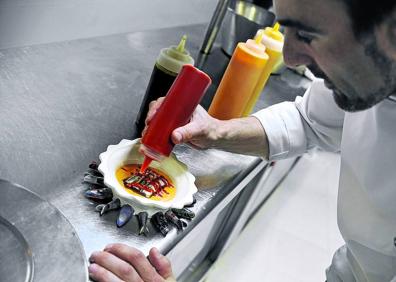 Imagen secundaria 1 - 1. Fernando Canales interactúa con la pantalla donde se condensa el cerebro del Atelier y la Despensa. Además de gestionar las comandas y el servicio, los nuevos platos podrán crearse aquí aunque los cocineros no se encuentren en el local. 2 y 3.Mikel Población, llamado a asumir un papel protagonista en la casa, ultima una lasaña de anchoas, una de las señas de identidad de Etxanobe y presente en los menús. A la derecha, ajoblanco de trufa con espárragos y gambas y (debajo), pulpo asado y espuma de patata y pimentón. Son platos de la nueva carta.