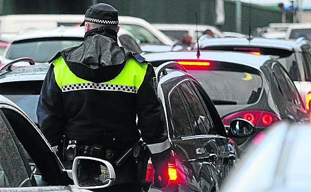 Un agente, entre las dobles filas en la puerta de un centro.