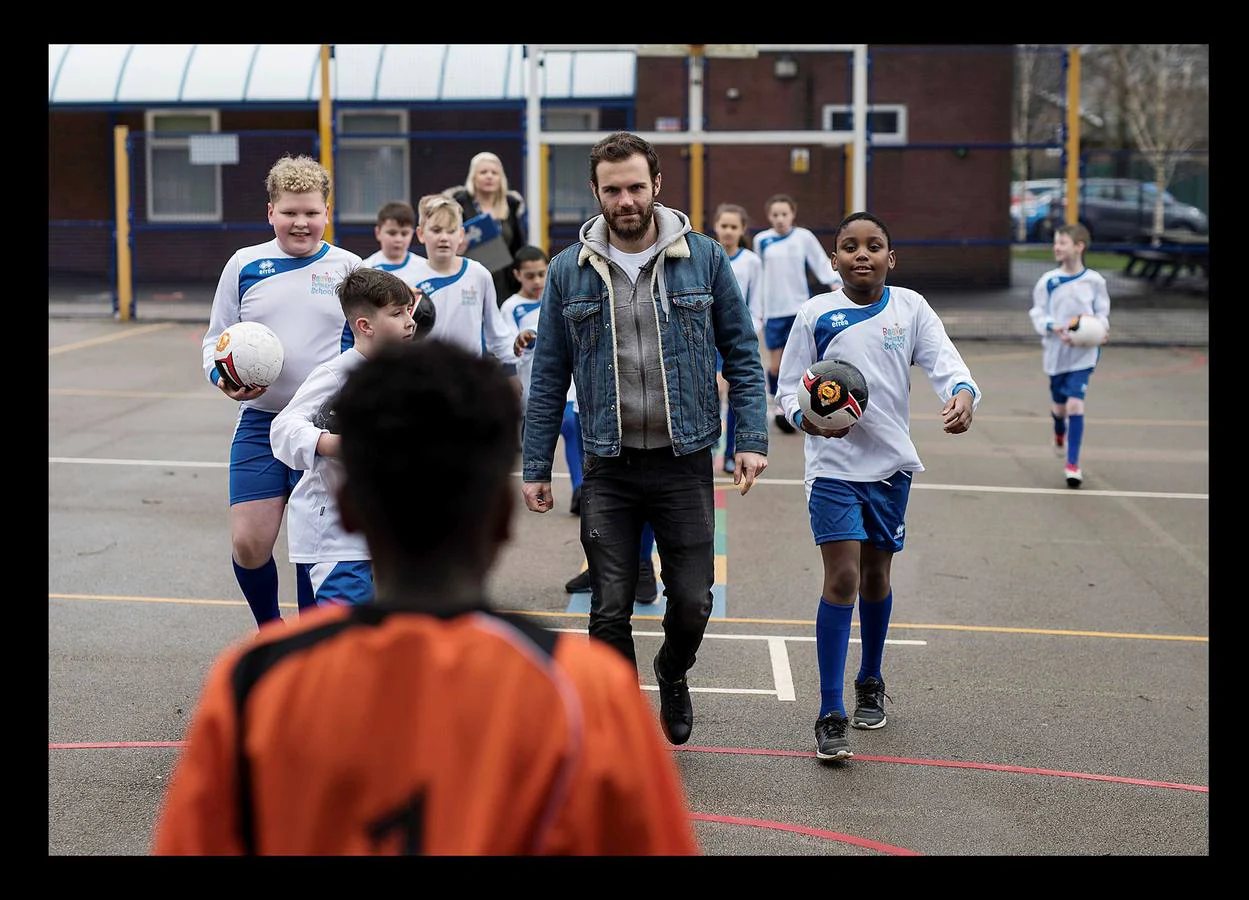 El futbolista español Juan Mata, centrocampista del Manchester United, quiere mejorar el mundo. Su iniciativa "Common Goal" (Objetivo Común), que busca la colaboración de sus compañeros del fútbol para que donen el 1 por ciento de sus salarios a fines benéficos, ha logrado por el momento la participación de 34 jugadores, entre ellos los internacionales Mats Hummels o Giorgio Chiellini. España cuenta con varios representantes que han decidido seguir esta acción, en especial en el fútbol femenino. "Mi gran ambición es lograr que el fútbol sea una herramienta para el cambio social y que este proyecto se convierta en el club más grande del mundo." En las fotografías, vemos a Mata durante una vista a la Beever Primary School, en Oldham, en la que participó en una clase de español, y en diferentes momentos de sus últimos partidos.