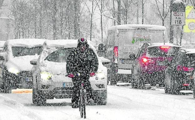 Un ciclista pedalea mientras la tormenta descarga con fuerza.