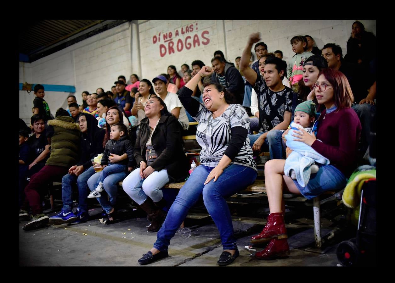 «¡Pinche vieja, vete a la cocina!,» se escucha desde la tribuna mientras la luchadora «Brillo de Luna», con leotardo fucsia salpicado de lentejuelas y botas altas, paraliza con un gancho a Guerrero Nazi, su adversario. A esta deportista mejicana de 42 años, madre de tres hijas, le parece bien que el público masculino la insulte en este combate deportivo-coreográfico. «Significa que estás haciendo bien tu trabajo porque sacan su frustración gritándote en lugar de humillar o golpear a sus esposas cuando vuelvan a casa.« Lucía Urbina, su nombre real, es una de las pocas luchadoras que suben al ring sin máscara para participar en las llamadas peleas mixtas -permitidas hace unos 20 años-, porque representan la “lucha de poder.» “Queremos demostrar al público y a ellos que nosotras también podemos, que no solo ellos y su fuerza, sino nosotras y todas las habilidades que tenemos, pueden sacar adelante un combate y rendirlos.» Siete mexicanas son asesinadas cada día pero sólo un 25% de los casos son investigados como feminicidios, según el Observatorio Ciudadano Nacional del Feminicidio.