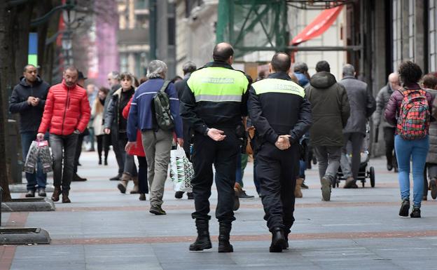 Dos agentes de la Policía Municipal de Bilbao patrullan a pie por la Gran Vía.