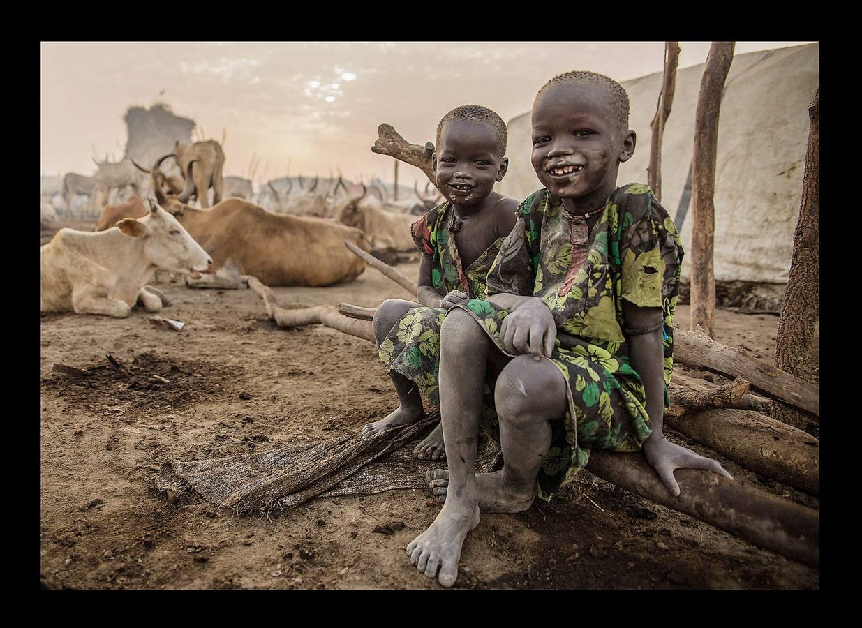 Cuando un varón de la tribu Dinka alcanza la pubertad debe sacrificar un toro. A partir de ese momento, el joven añade a su nombre el color del pelaje de la res, que lo acompañará para siempre. Los Dinka, más de un millón de personas, son la etnia mayoritaria en Sudán del Sur, casi un 70 por ciento, según estimaciones, y son considerados los primeros pobladores esa región, en las orillas del Nilo, donde se establecieron en el siglo X. Para un dinka la posesión más preciada es el ganado bovino, ya que del número de animales que posea dependerá su prestigio social, su riqueza y hasta sus posibilidades de contraer matrimonio. Toda su vida gira y depende de las vacas: beben su leche, usan sus pieles y se arreglan el pelo con su orina y estiércol para lograr que tome un tono rojizo, característico de la belleza de esta etnia.