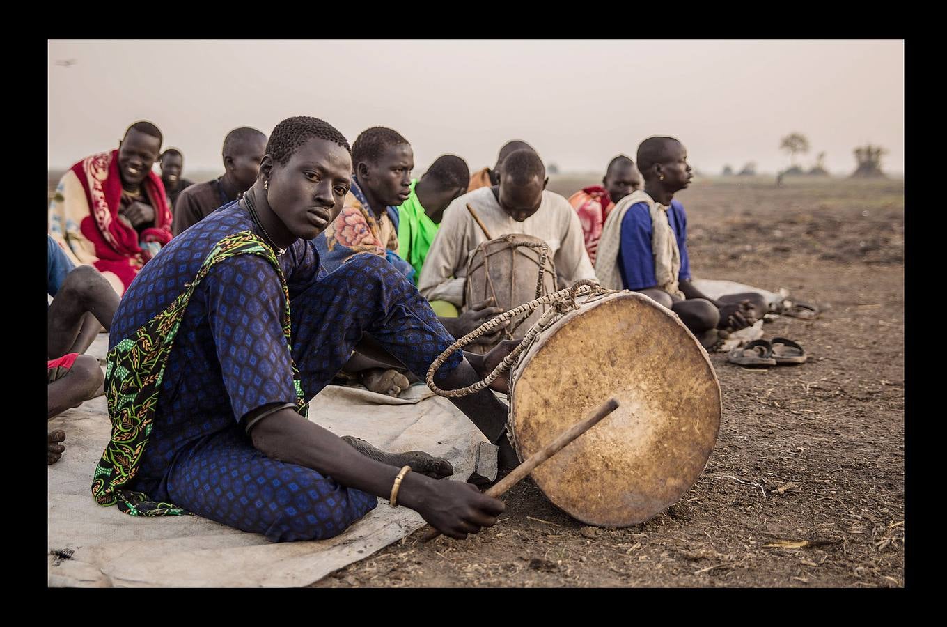 Cuando un varón de la tribu Dinka alcanza la pubertad debe sacrificar un toro. A partir de ese momento, el joven añade a su nombre el color del pelaje de la res, que lo acompañará para siempre. Los Dinka, más de un millón de personas, son la etnia mayoritaria en Sudán del Sur, casi un 70 por ciento, según estimaciones, y son considerados los primeros pobladores esa región, en las orillas del Nilo, donde se establecieron en el siglo X. Para un dinka la posesión más preciada es el ganado bovino, ya que del número de animales que posea dependerá su prestigio social, su riqueza y hasta sus posibilidades de contraer matrimonio. Toda su vida gira y depende de las vacas: beben su leche, usan sus pieles y se arreglan el pelo con su orina y estiércol para lograr que tome un tono rojizo, característico de la belleza de esta etnia.