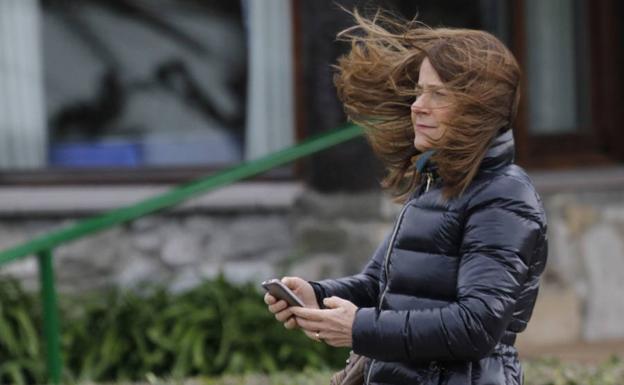 Una mujer lucha contra el viento en Aixerrota.