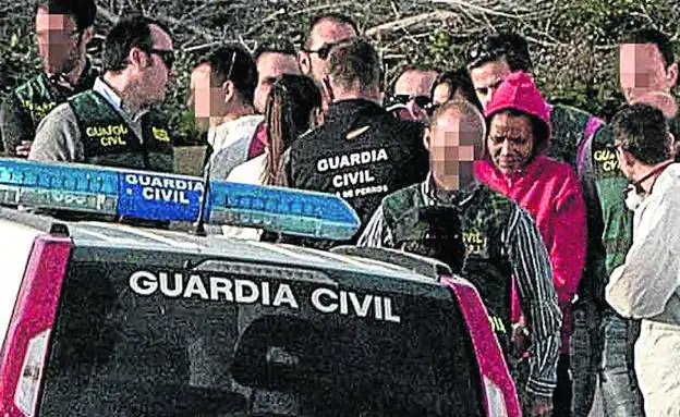 Ana Julia Quezada, con sudadera roja, es conducida por los agentes en el registro de la finca de Rodalquilar donde enterró el cuerpo del niño.