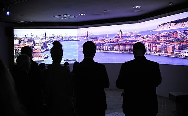 Los asistentes observan un video proyectado en el acto inaugural.