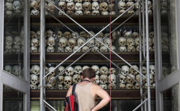 Un turista contempla un momumento conmemorativo erigido con 8.000 craneos de camboyanos asesinados bajo la dictadura de Pol Pot.