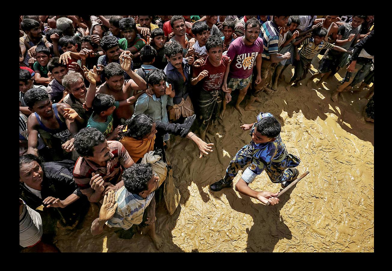 Un oficial de seguridad intenta controlar a los refugiados rohinyás que esperan recibir ayuda en Cox's Bazar (Bangladés), el 21 de septiembre de 2017.