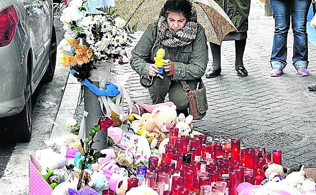 Una mujer coloca un muñeco en el altar improvisado en memoria de la pequeña Alicia. 