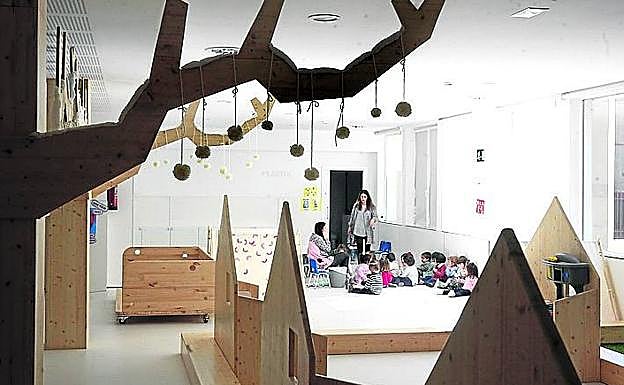 Imagen principal - Zona de Infantil de Carmelitas, con aires nórdicos. Una mesa de luz creada por el profesorado de Ikasbidea y clases comunicadas con paneles móviles.