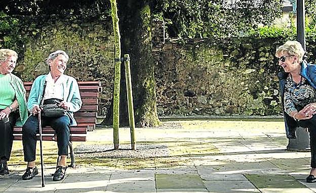 Ana Atxutegi, a la derecha, conversa con un grupo de mayores en los bancos de Begoña. Algunas charlas ayudan a destapar situaciones de emergencia.